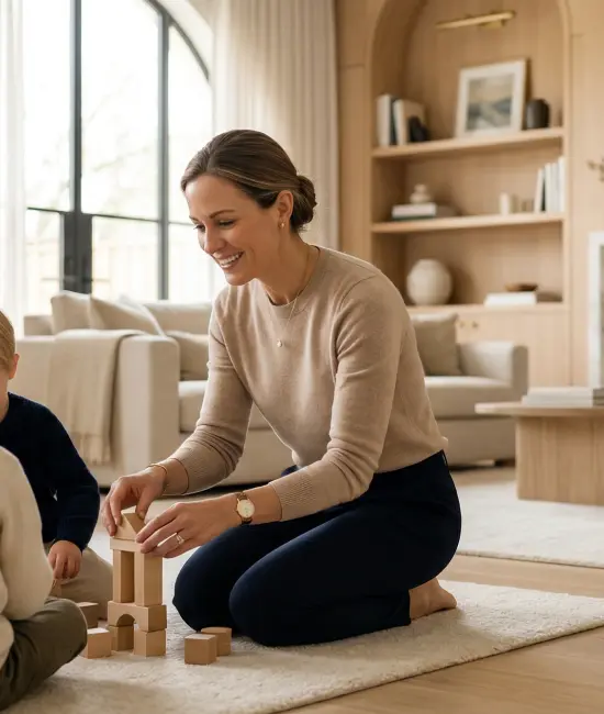 Private estate nanny guiding young children through play-based learning in a refined family home.