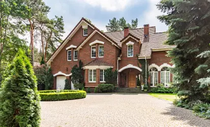 Private estate residence managed by a professional house manager, with a grand brick exterior, landscaped grounds, and a sweeping driveway.