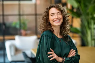 Modern PA smiling in an office, reflecting the changing role of personal and executive assistants.