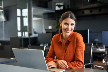 Professional personal assistant working at a laptop, representing why a strong PA is one of a principal’s most important hires.